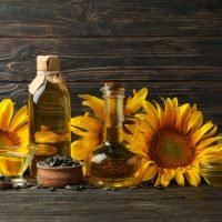 Composition with sunflower, oil and seeds on wooden background