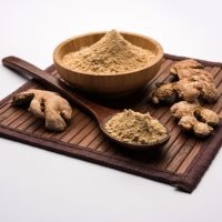 Ginger or Adrak powder with dried whole, also known as Sunth or Sonth in India, Over moody background. selective focus